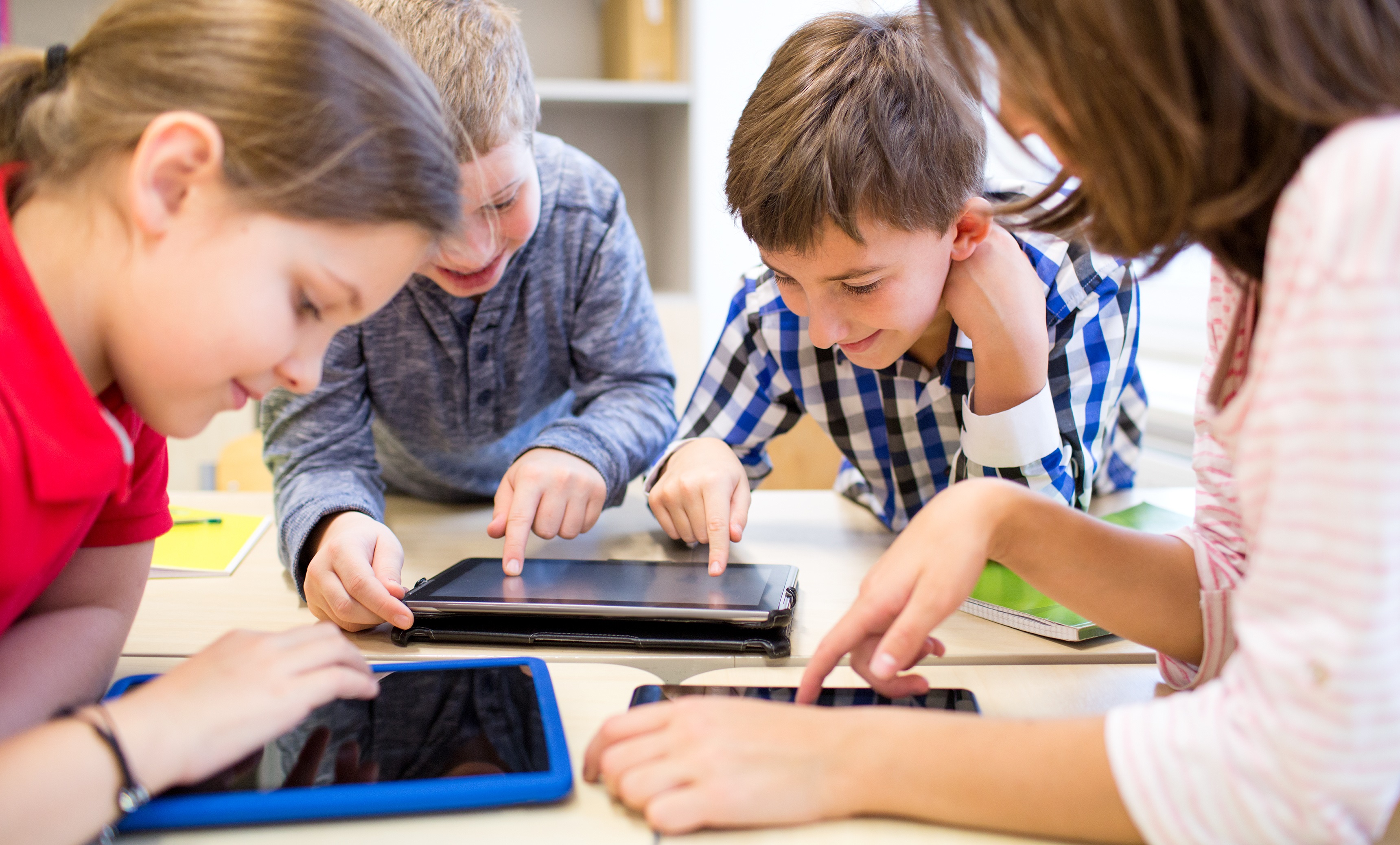group of school kids with tablet pc in classroom