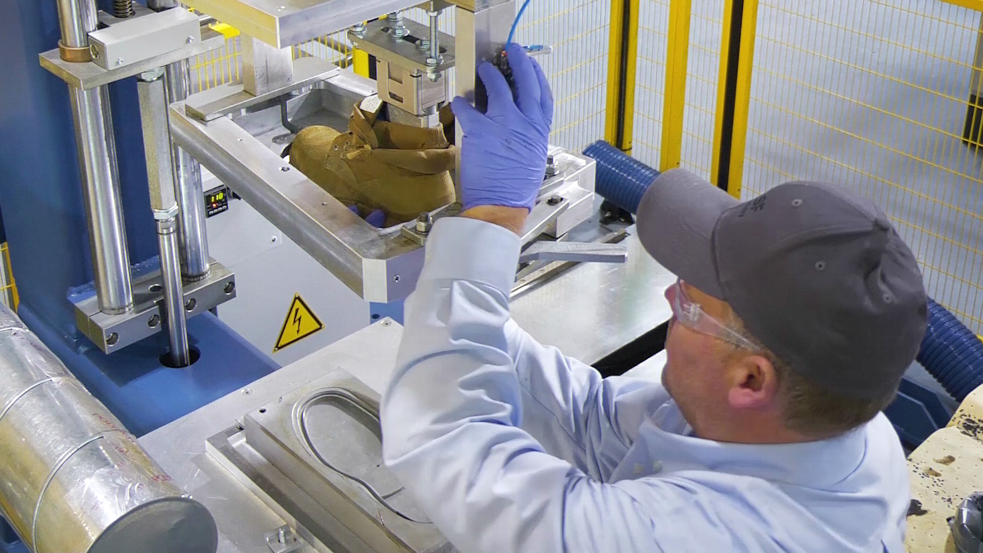 A BASF employee pulls a shoe out of the mold on a GUSBI machine. Footwear Development Center in Wyandotte, Michigan / Ein BASF-Mitarbeiter an GUSBI-Maschine einen Schuh aus der Form. Footwear Development Center in Wyandotte, Michigan